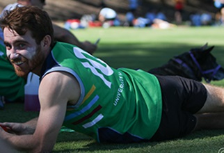 Resident lying on grass in green sport uniform after a game