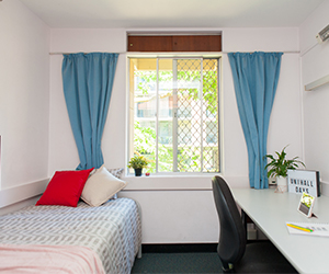 Image of the bed and study desk space within a standard room