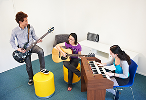 Residents jamming out in the music room on guitar and piano