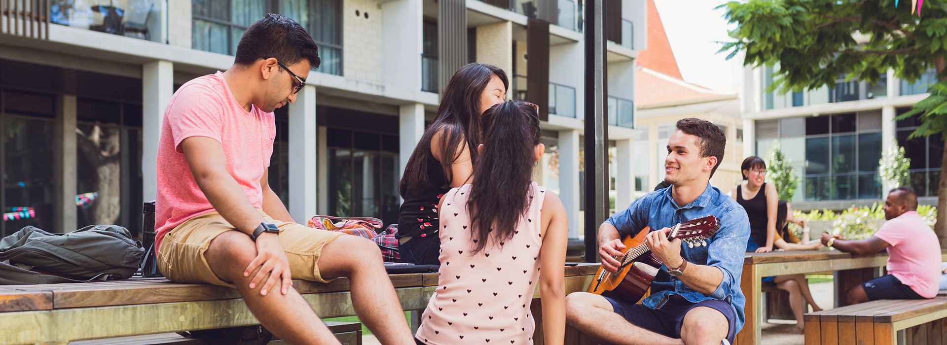 Image of students playing guitar in lower quad