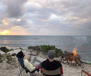 Image of two friends camping on the coastline