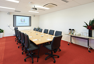 Boadroom with long table, projector and screen