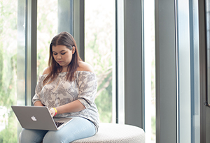 UniHaller studying privately on her laptop in common area