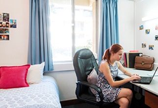 Female resident studyingat desk in standard room