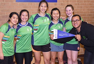 The winning female badminton team proudly holding their flag