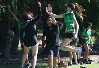 Students jumping and high fiving at a sporting event