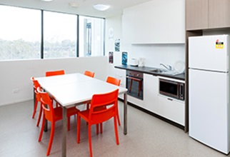 Common kitchen with oven fridge and Dining table and chairs