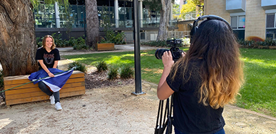 Image of student holding their national flag being filmed for the Language Videos