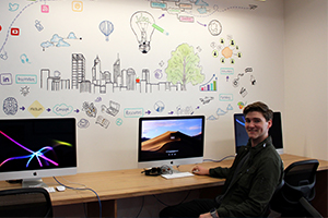 Image of student Rafe at the computers in the Innovation Space